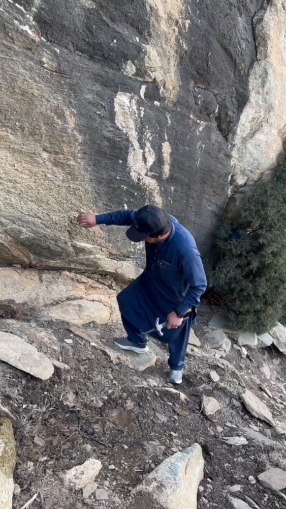 Collector working a seam at the rock face with a hand tool